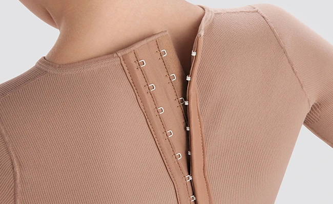 Finishing detail of a eye and hook back closure of a compression vest.