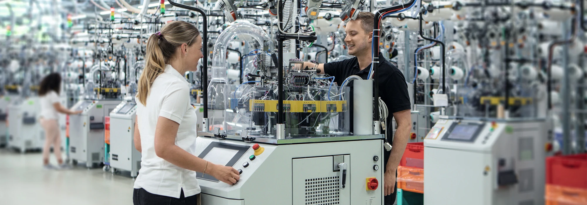 Two technical team are checking the circular knit machine at juzo production facility in germany.
