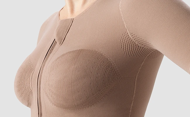 Close-up detail of compression garment fabric showing breathable texture at breast and under arm